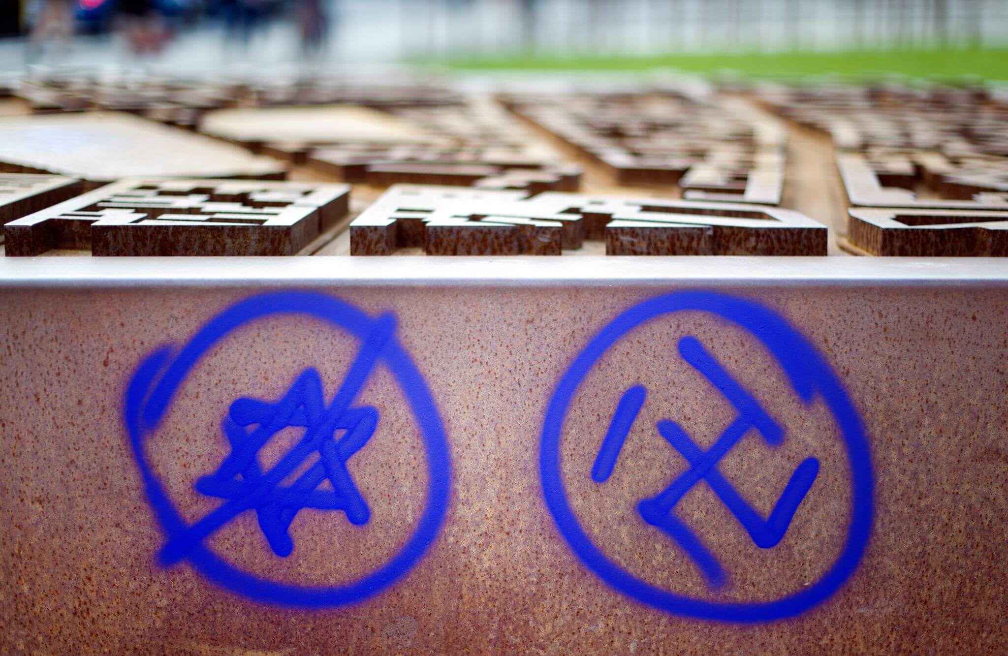 Hakenkreuz und durchgestrichener Davidstern an einer Gedenkstätte