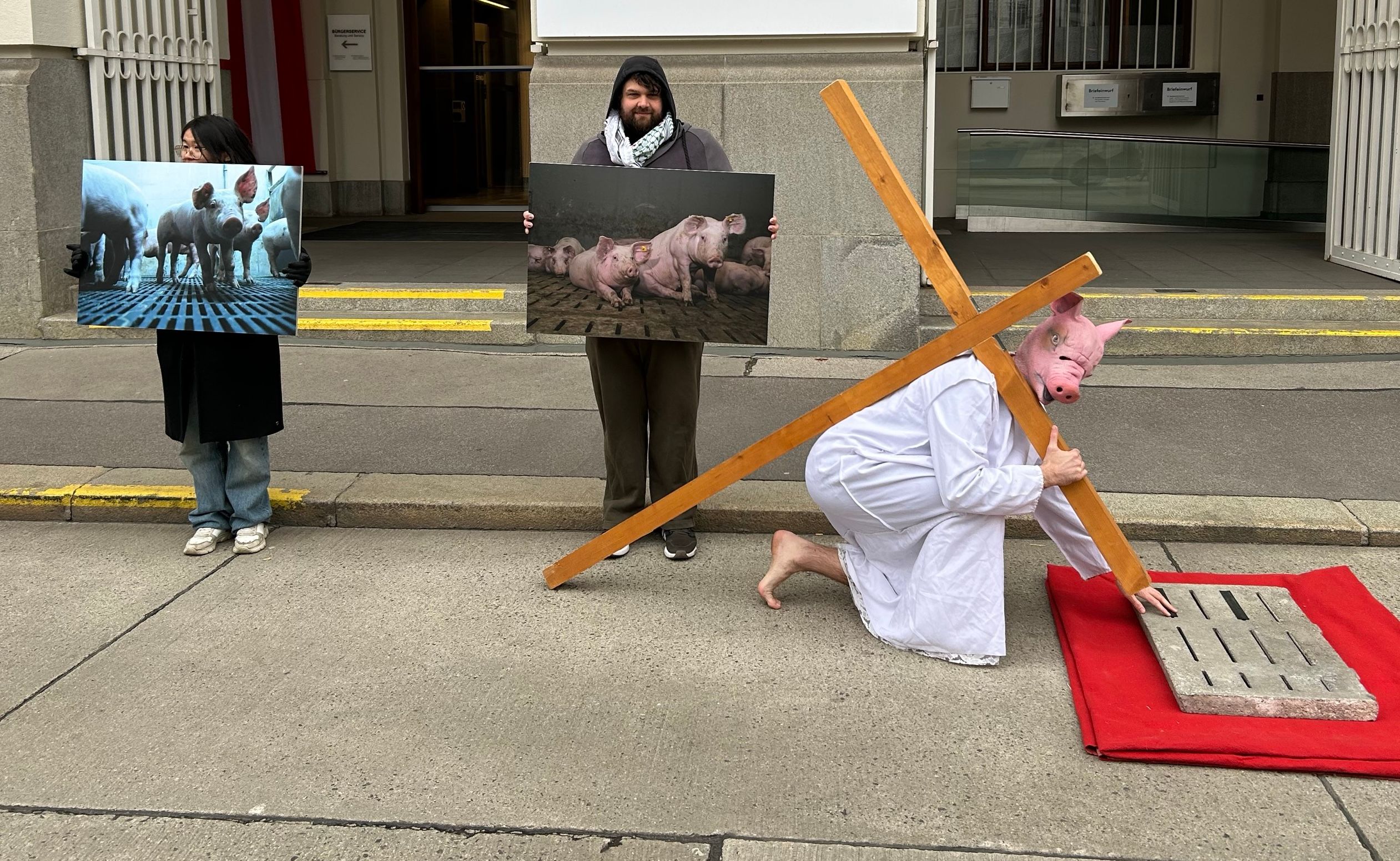 Nachgestellte „Leidensstation“: Eine Figur mit Schweinemaske trägt ein Holzkreuz.