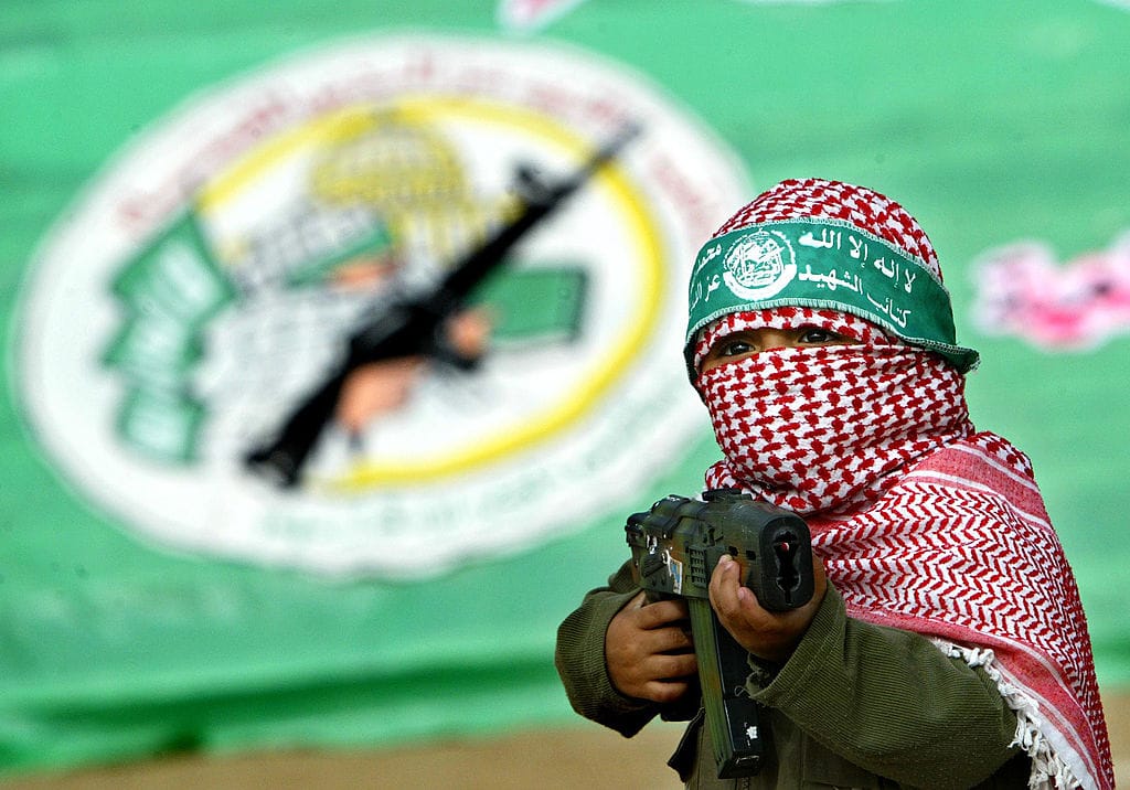Maskierter Bub mit Spielzeugwaffe bei einer Hamas-Veranstaltung: ein Beispiel dafür, wie Gewalt und Ideologie früh vermittelt und normalisiert werden.
