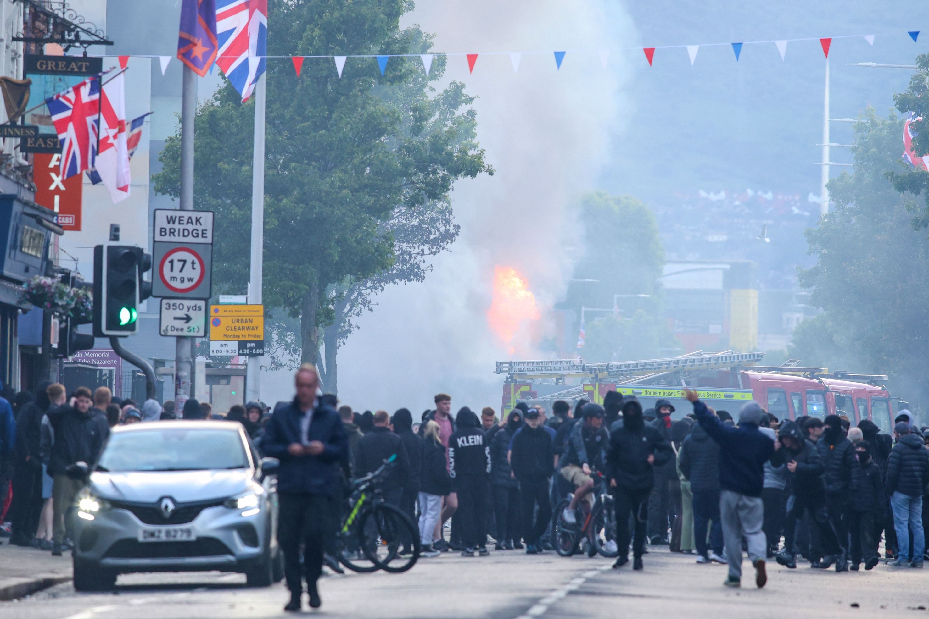 Ein Bus brennt auf der Newtownards Road in Belfast: Die Polizei rief zur Ruhe auf, nachdem Proteste nach der Messerattacke eskalierten.